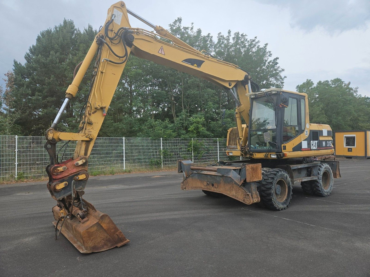 CAT M315 Mobilbagger mit Pratzen und Schild - Pelle sur pneus: photos 1 CAT M315 Mobilbagger mit Pratzen und Schild - Pelle sur pneus: photos 1