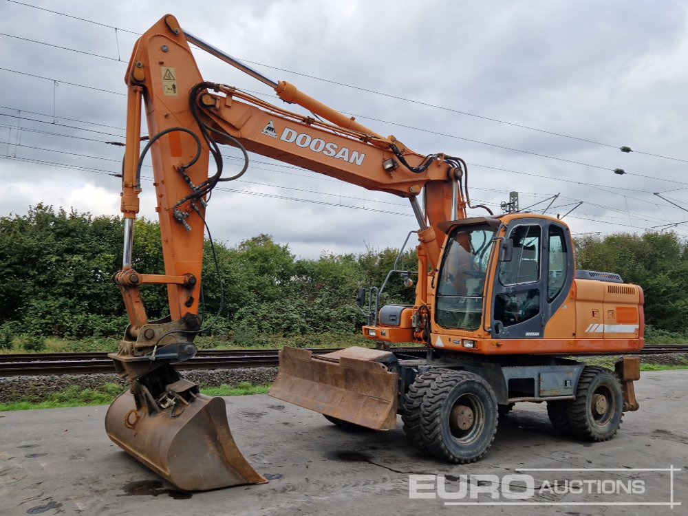 Doosan DX210W - Pelle sur pneus: photos 1 Doosan DX210W - Pelle sur pneus: photos 1